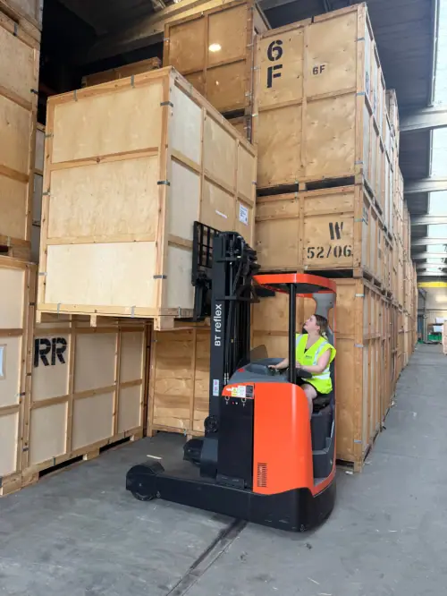 Regal Moving & Storage staff using a forklift to lift a storage pod for stacking