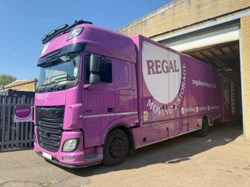 Purple Regal Moving & Storage truck partially inside warehouse