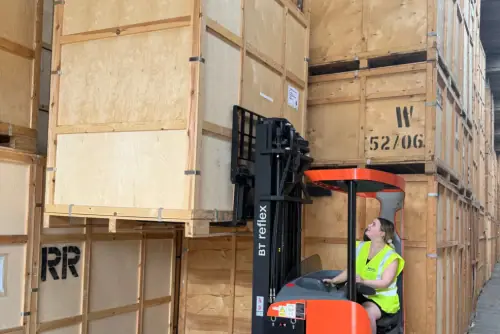 Regal Moving & Storage staff using a forklift to lift a storage pod for stacking