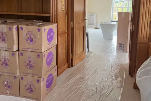 Inside a client’s house: Regal Moving & Storage boxes neatly stacked with a wardrobe box and an empty cabinet