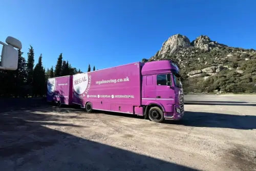 Regal Moving & Storage branded purple removal lorry with a mountain backdrop