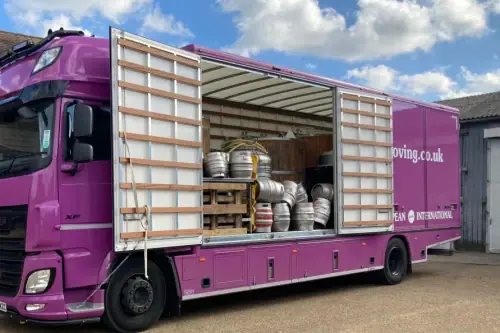 Regal Moving & Storage purple removal truck with side door open, loaded with barrels