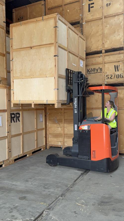 Regal Moving & Storage staff using a forklift to lift a storage pod for stacking