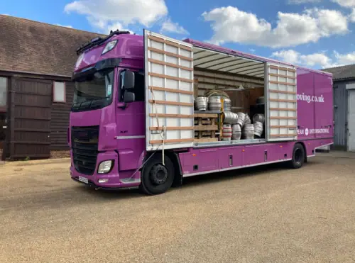 Regal Moving & Storage purple removal truck with side door open, loaded with barrels